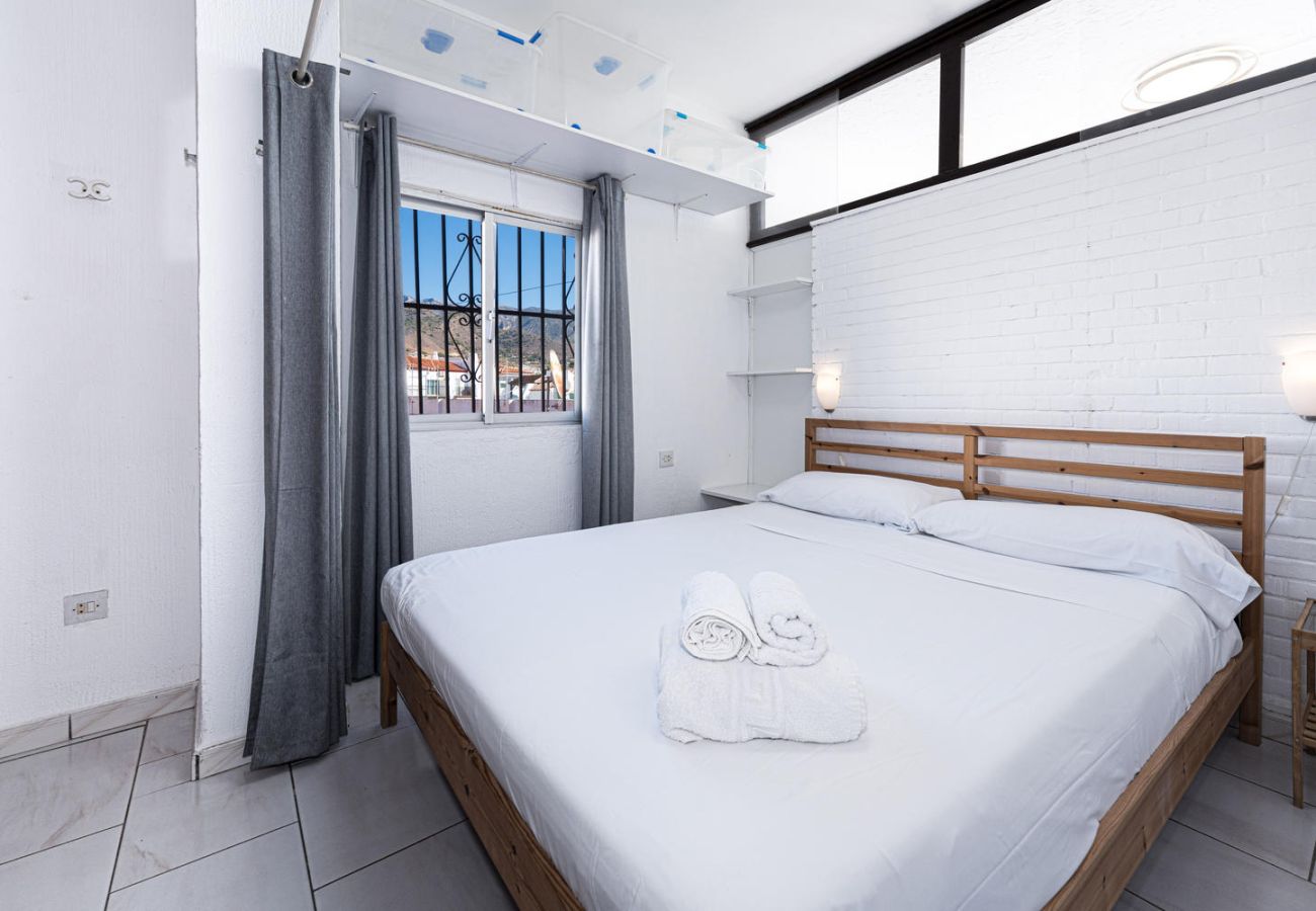 Dormitorio principal con cama doble y lencería profesional.