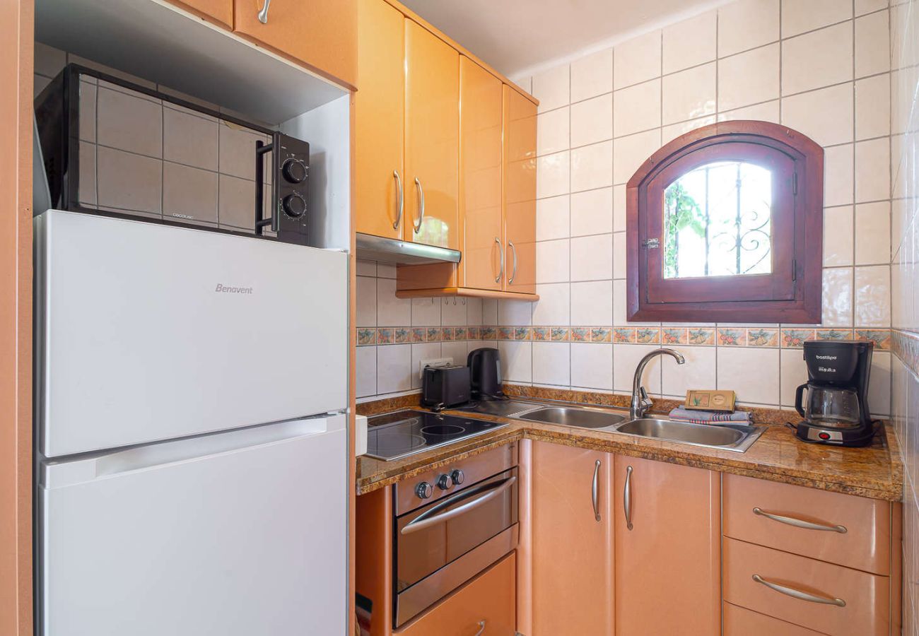 Cocina abierta totalmente equipada con horno, microondas y electrodomésticos modernos.