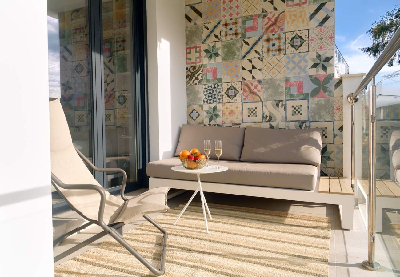 Zona lounge exterior con sofá en terraza privada frente al mar en Balcón del Mar.