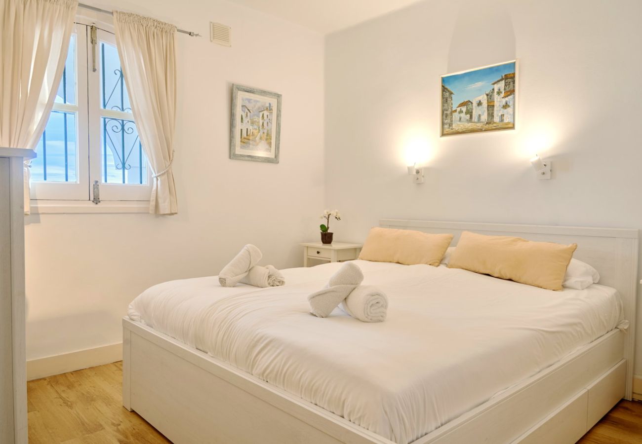 Dormitorio principal con cama doble y luz natural en apartamento vacacional.