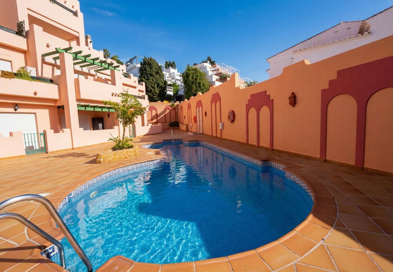Piscina comunitaria rodeada de terrazas en complejo residencial cerca de Playa Burriana Nerja.