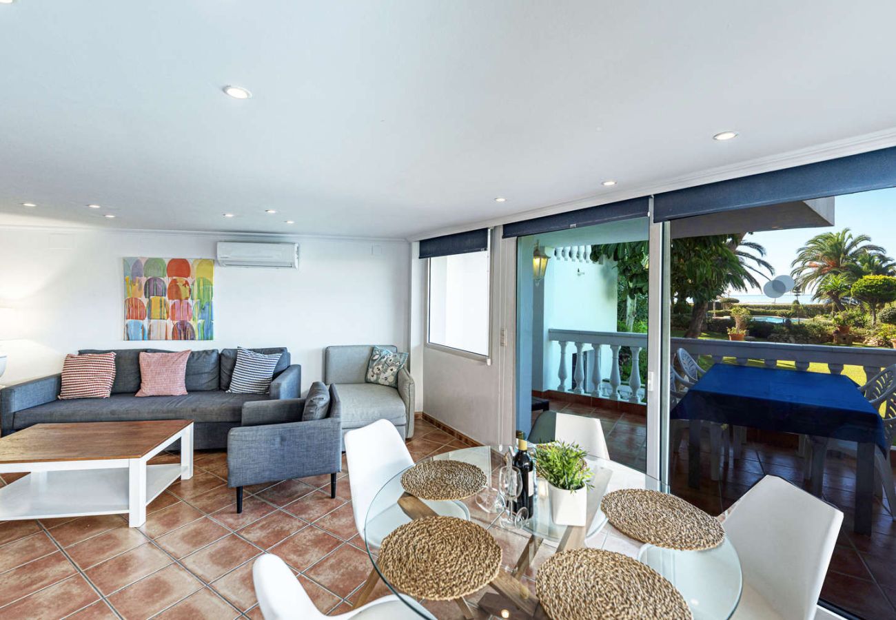 Interior del salón con vistas despejadas al mar y la piscina a través de los ventanales de la terraza