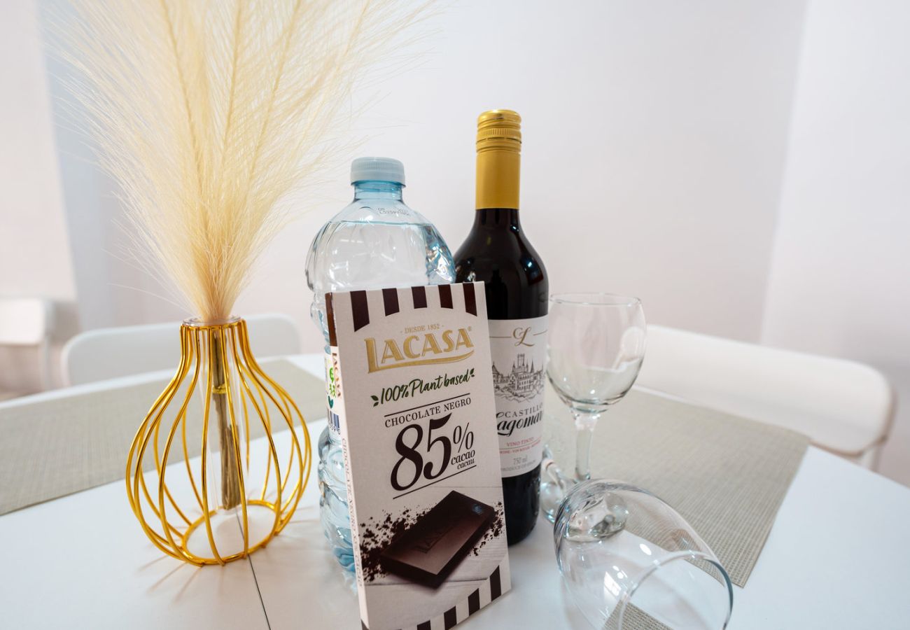Botella de vino, botella de agua y chocolate de cortesía