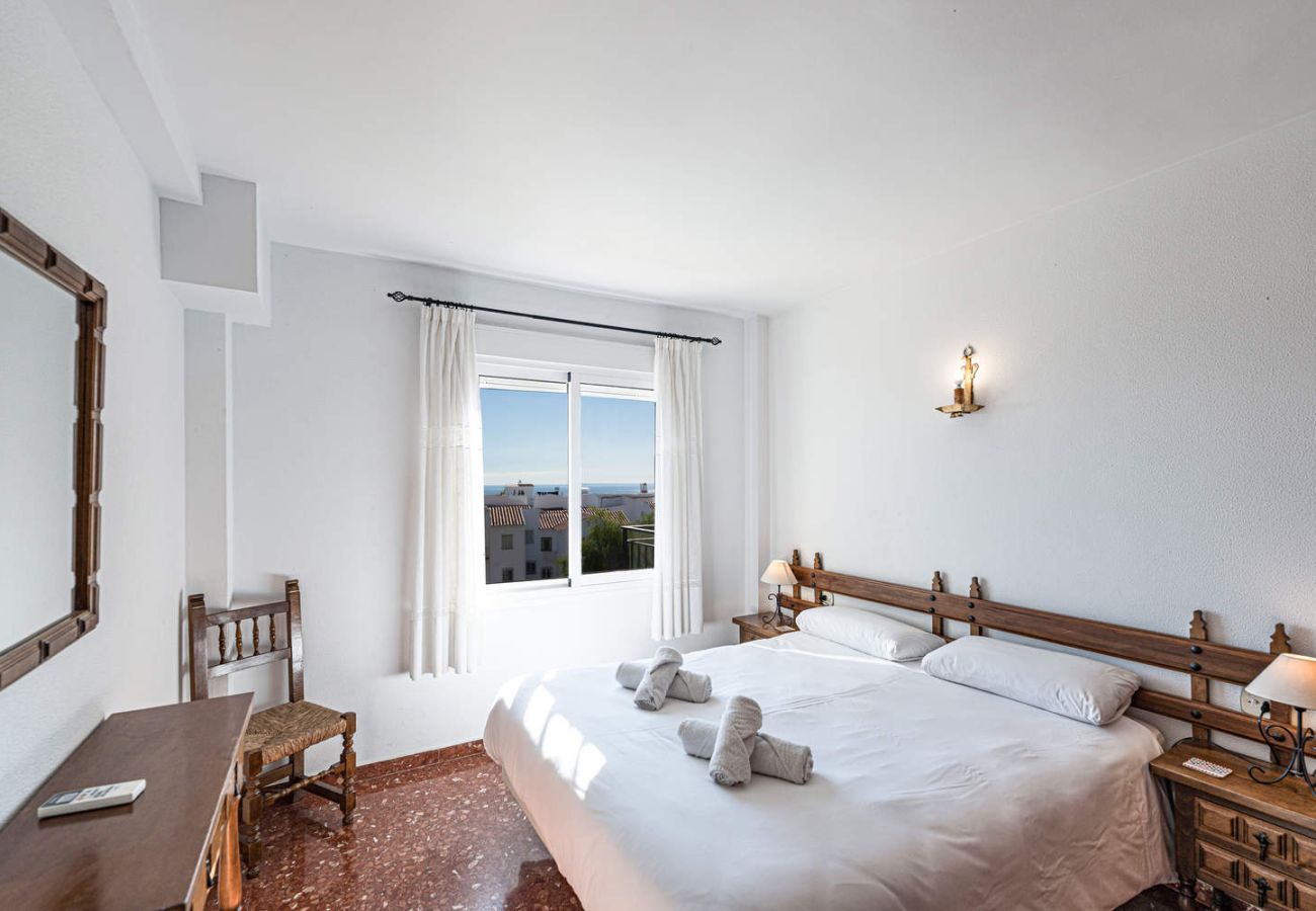 Habitación con cama doble y vistas al mar en apartamento de Nerja