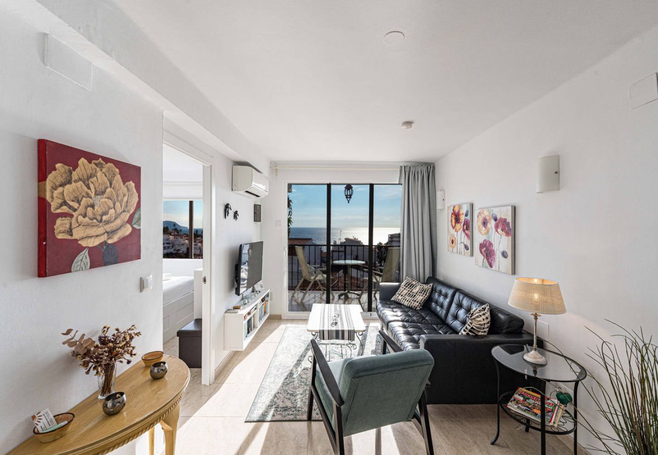 Sala de estar con sofá y TV en apartamento en Nerja