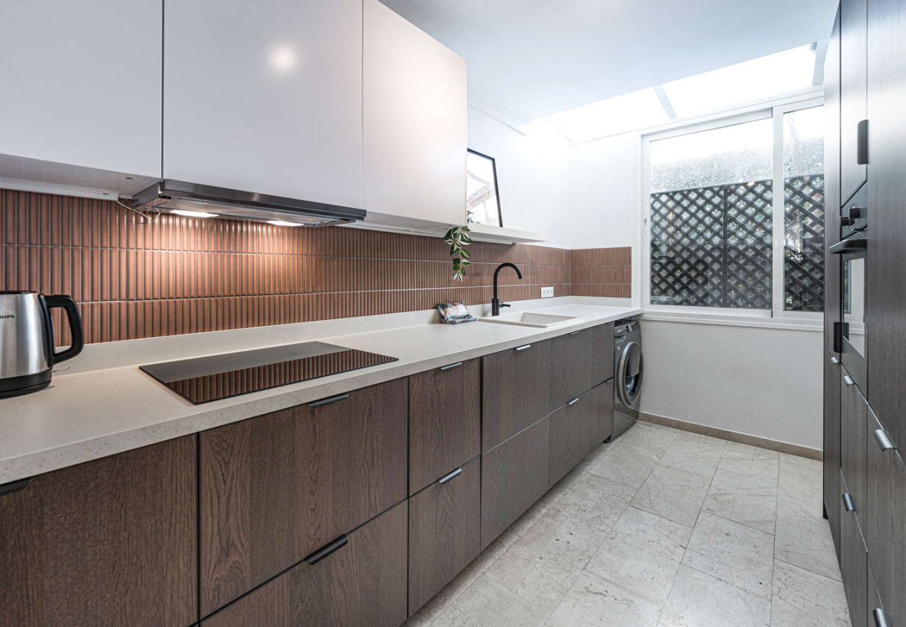 Cocina moderna totalmente equipada con horno, microondas y diseño elegante en alojamiento vacacional.