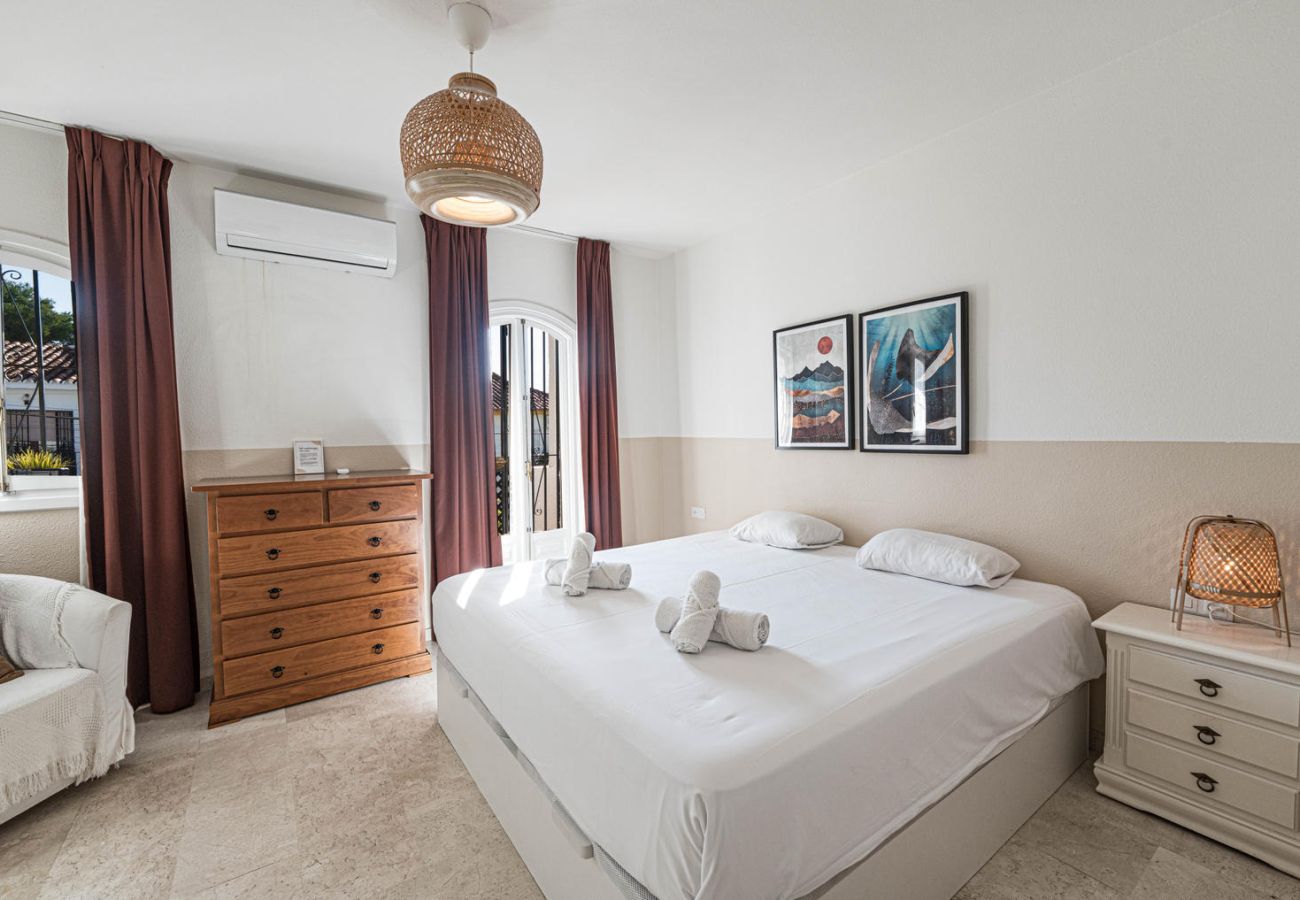 Dormitorio principal con cama de matrimonio, balcón privado y decoración acogedora en Nerja.