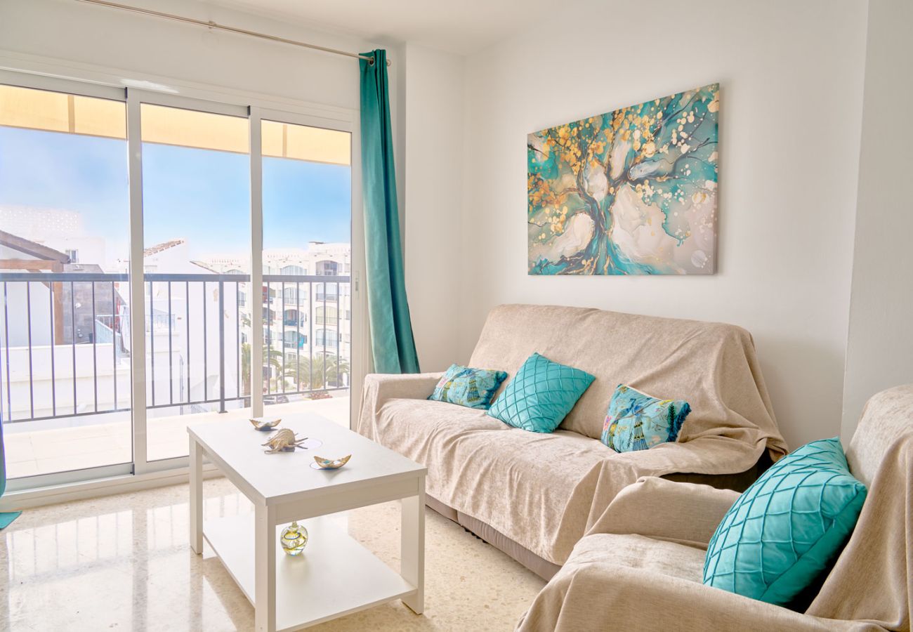 Zona de estar con sofás y televisión en el apartamento Tucuman 3 en el centro de Nerja.