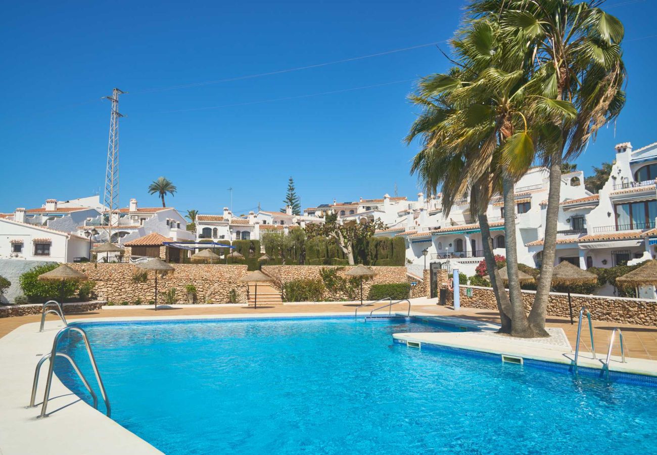 Piscina comunitaria de Casa Sofia, rodeada de jardines en el complejo Capistrano Village, Nerja.