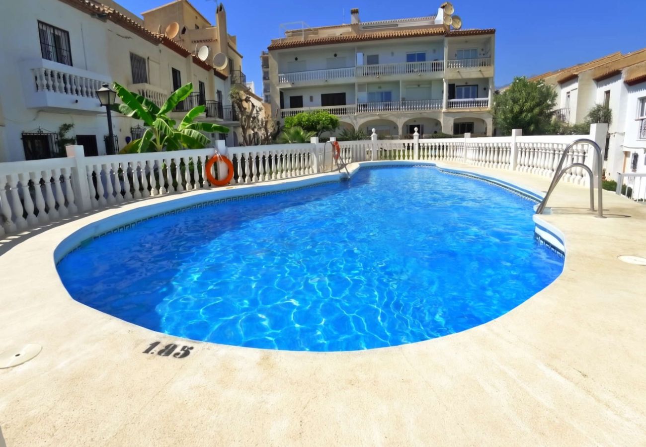 Piscina comunitaria rodeada de jardines en la urbanización La Hacienda, Nerja.
