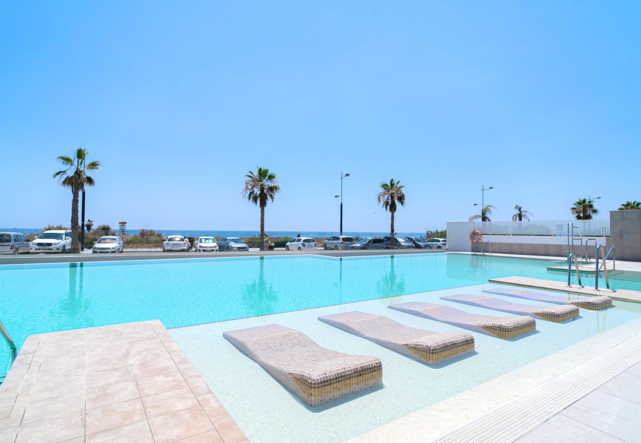 Piscina infinity comunitaria y Playa de las Dunas en Torrox Costa.