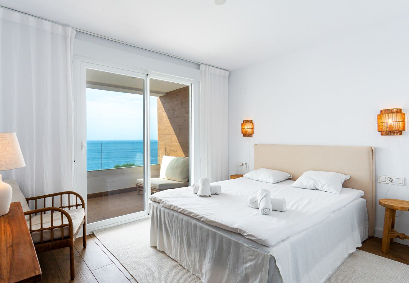 Dormitorio principal con cama queen size y vistas al mar en Isea Calaceite